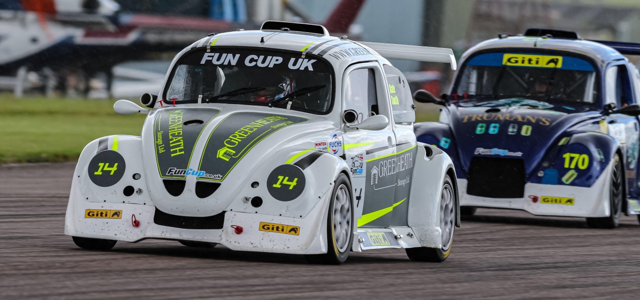 Two Volkswagen Beetles on the track during a motorsport event called Fun Cup UK.