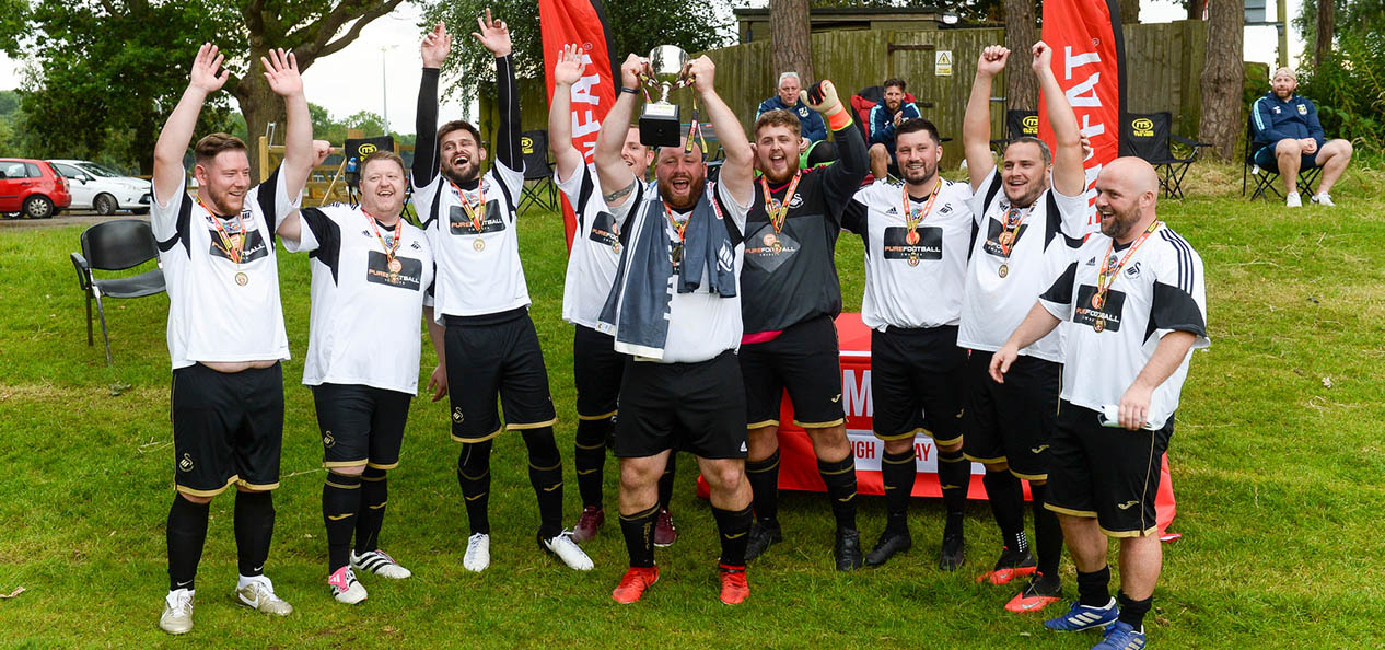 Men from the MAN V FAT programme celebrate a victory after an outdoors football game.