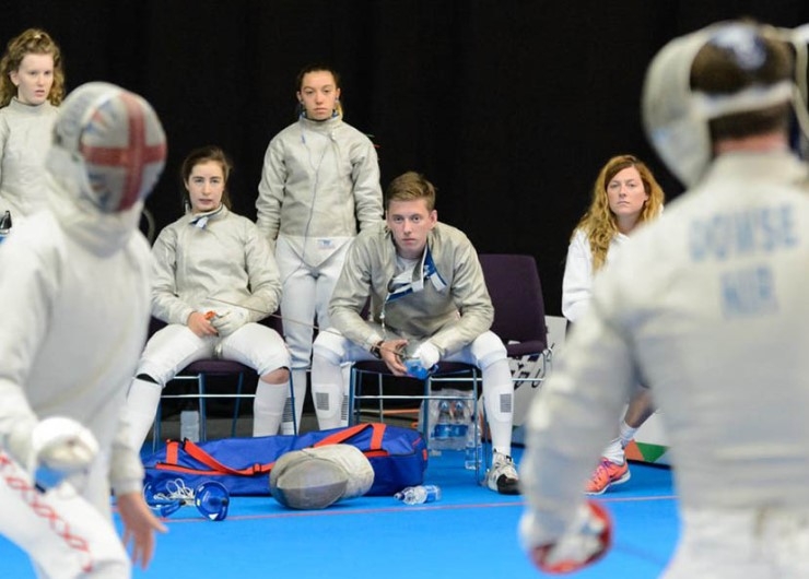 Young fencers watch a contest.