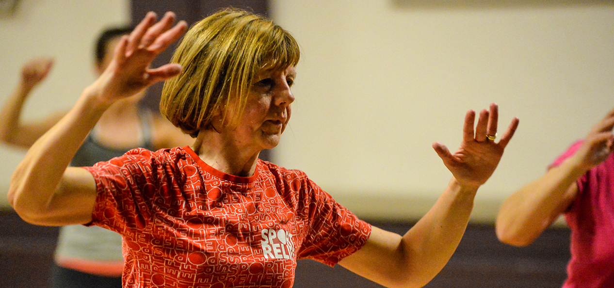 A woman exercising as part of a class.