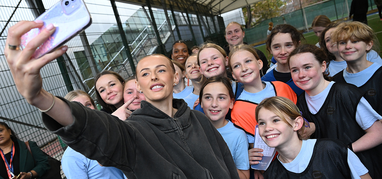 England footballer Chloe Kelly takes a selfie with a groups of girls at an after-school football club