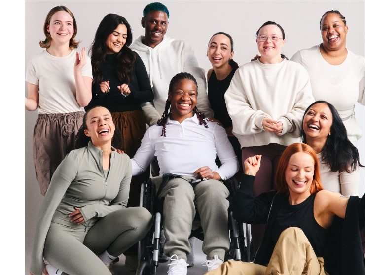 A group of women with a variety of characteristics smile for a posed shot.