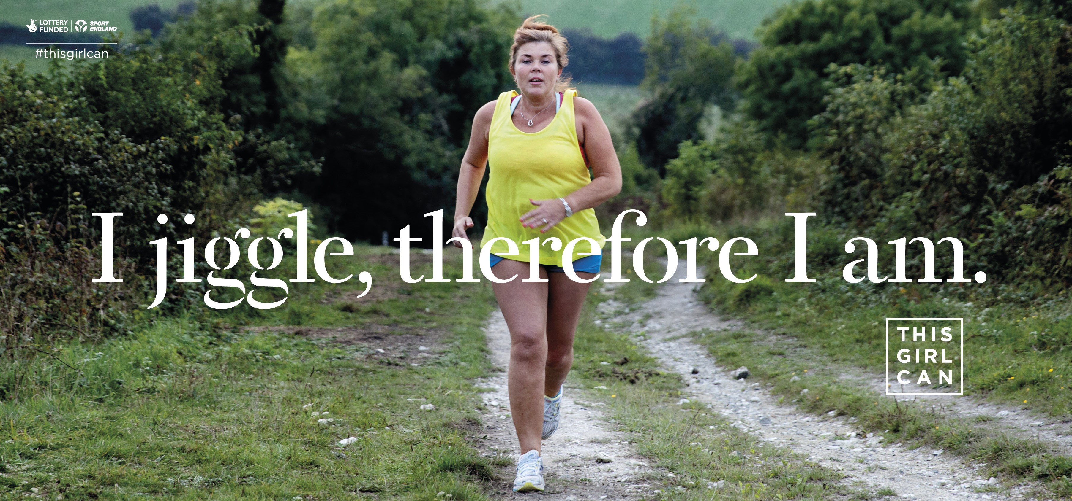 A woman jogs on a country track, with overlaid text reading 'I jiggle, therefore I am', and the logos of This Girl Can, Sport England and The National Lottery on the sides.