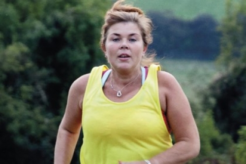 A woman jogs on a country track.