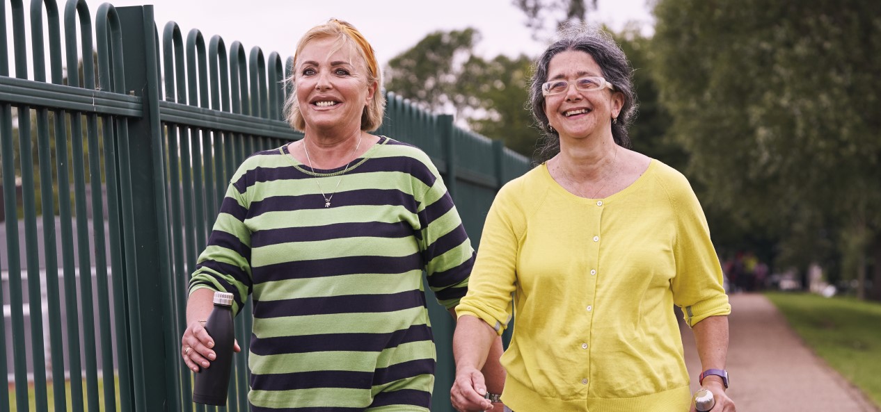 Two women walking in a park with water bottles